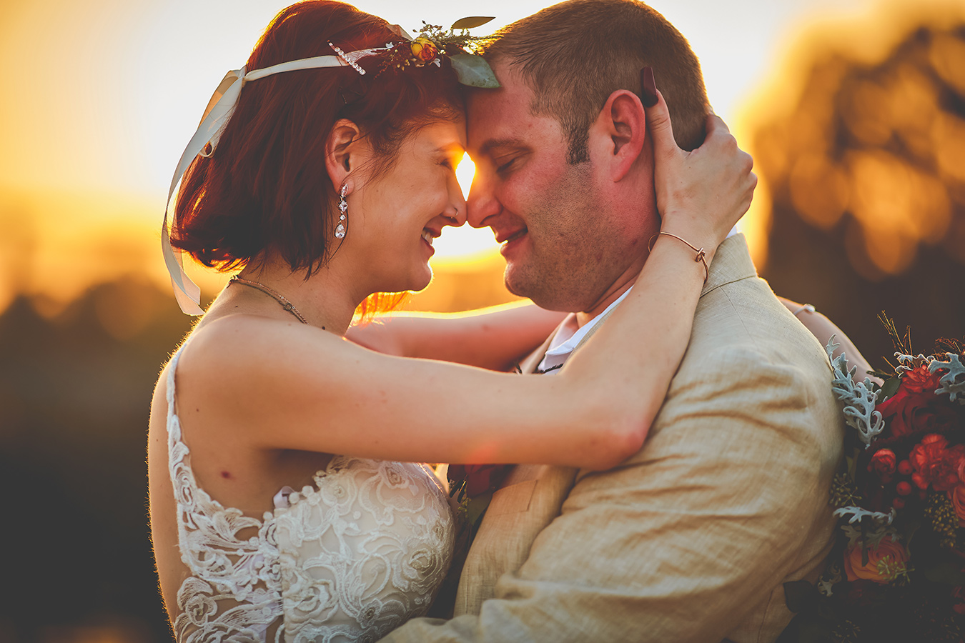 Jenny and Daniel with their foreheads and noses touching with the sun setting in the background